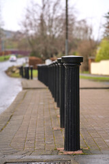 Beautiful vertical view of inline black metal road blockers to prevent vehicles getting parked on...