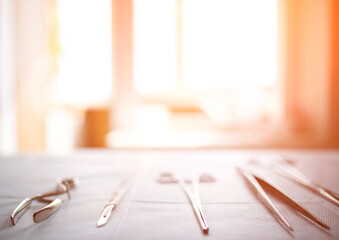 Surgical instruments on the table in the operating room of the hospital. Sunny sunset in the window. Surgery concept, amputation, complications after surgery. Copy space for text