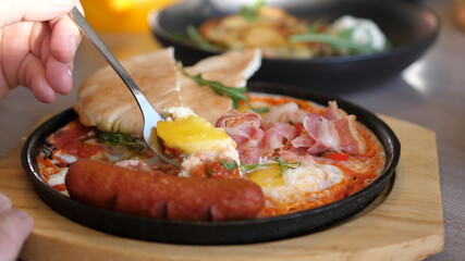 Eating Shakshuka Poached Eggs with Tomato and Bread Served in a Frying Pan. Israeli Arab Middle Eastern Cuisine. 4k