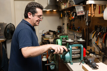 a man stretches a piece of silver to make a ring.