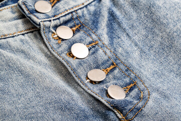 Stylish buttons on a trendy denim skirt, background, macro.