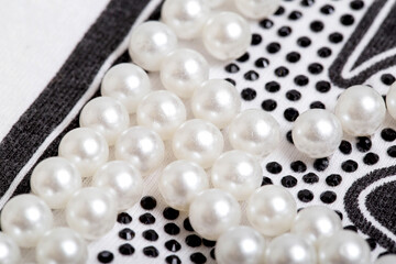 Beautiful pearl decoration in the form of white balls on stylish clothes, macro