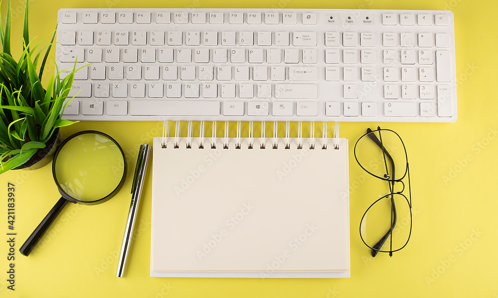 Poster office desk table top view with keyboard and notebook copy space yellow background