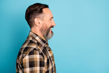 Side profile photo portrait of man smiling looking empty space in plaid shirt isolated on bright blue color background
