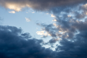 Detail of a white cloud in a bright blue sky. 
Dark rain clouds displace the blue sky. Storm is...