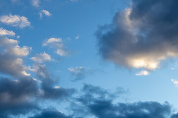 Detail of a white cloud in a bright blue sky. 
Dark rain clouds displace the blue sky. Storm is coming 