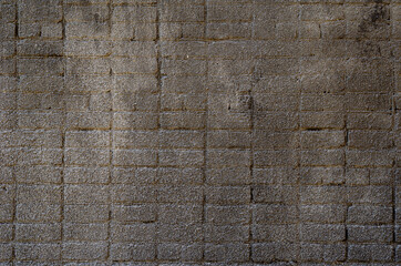 The brick wall is covered with dark gray cement plaster.