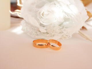 Wedding rings and flowers blurred background