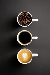 Obraz na płótnie Canvas Tasse mit Kaffeebohnen + Tasse mit schwarzen Kaffee + Tasse mit Milchschaum und Herz