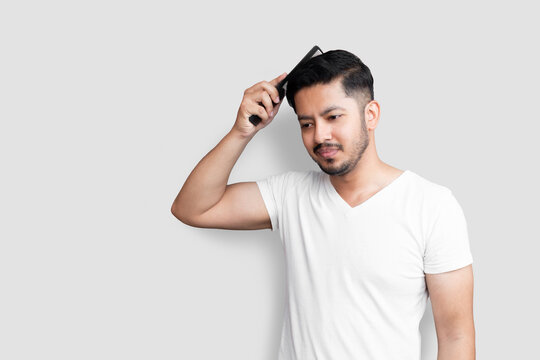 Close up photo amazing young age perfect appearance hands arms plastic hair styling brush take care hairdo after barber shop visit wear casual white t-shirt isolated white background