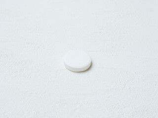 Pill of aspirin on white background.