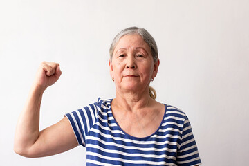 Elderly woman, 60s gray-haired lady in striped white and blue dress, strong man showing arm muscles, confident and proud of his power on white background