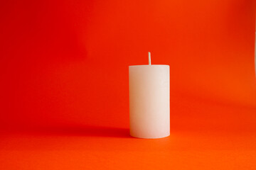 White large candle isolated on a red background. Place for your text. The decor is festive. Valentine's Day