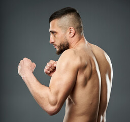 Athletic fighter posing on gray