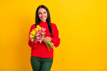 Photo of young happy positive good mood girl looking copyspace dreaming hold flowers isolated on yellow color background