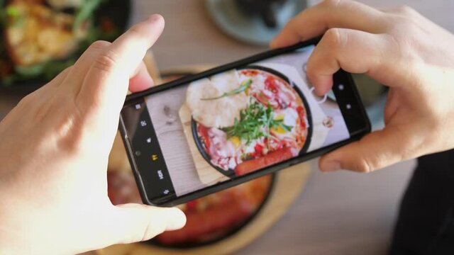Taking Mobile Photo of Shakshuka Poached Eggs with Tomato and Bread Served in a Frying Pan. Israeli Arab Middle Eastern Cuisine. Top View. 4k