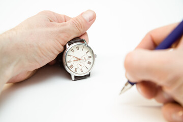 hand holding alarm clock, Watch in hand, pen in hand, time exam, lesson time.