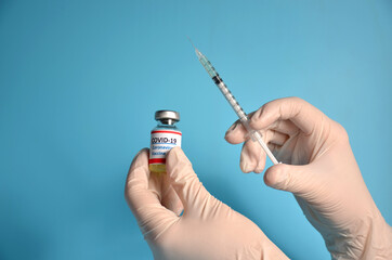 Spray and vaccine vial on a blue background.