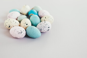 A pile of pastel colored decorative easter eggs. White background, copy space.