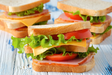Three tasty sandwiches on rustic wooden background