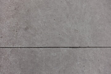 Fototapeta premium Gray concrete slab with joint dividing it in two uneven parts
