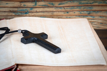 Bible and wooden cross on a wooden shelf. Faith and religion