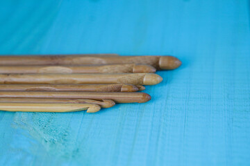 Wooden natural bamboo crochet hooks of different sizes on old wooden table