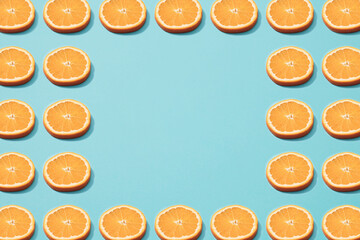 Slices of orange on blue background. Minimal pattern. Copy space.