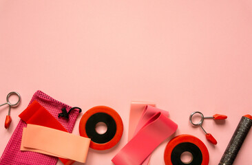Flat lay of sports equipment. Fitness rubber bands and dumbbells on pink background, space for text