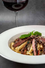 With sliced ​​grilled meat on a creamy penne pasta.