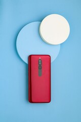Red smartphone on the blue round board, Blue table