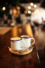 Side view on two mugs of morning coffee on the cafe desk