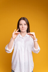 Young woman on isolated yellow background showing game with hands