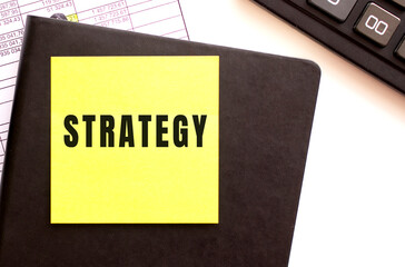 STRATEGY text on a sticker on your desktop. Diary and calculator.
