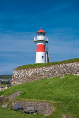 Fototapeta na wymiar Old lighthouse and fortress in the harbor of Torshavn, the capital of Faroe islands archipelago in Atlantic ocean, summer.