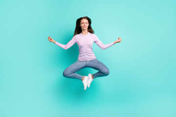 Full length body size view of attractive dreamy girl jumping sitting lotus pose meditating isolated over turquoise bright color background