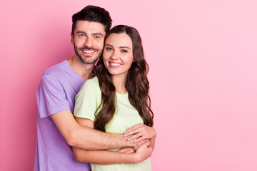 Portrait of attractive sweet tender cheerful couple embracing sweetheart isolated over pink pastel color background