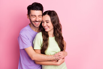 Portrait of attractive dreamy gentle tender cheerful couple embracing enjoying isolated over pink pastel color background