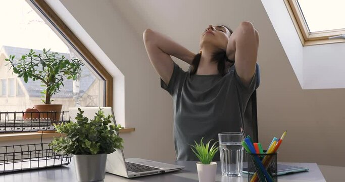 Beautiful women exercising at home office by stretching her neck. Healthy living and body care while at home.