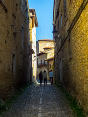 Tres personas pasean por las estrechas calles con casas de piedra de la aldea medieval de Santillana del Mar, España