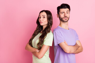 Naklejka premium Profile side view portrait of attractive serious couple standing back to back folded arms isolated over pink pastel color background