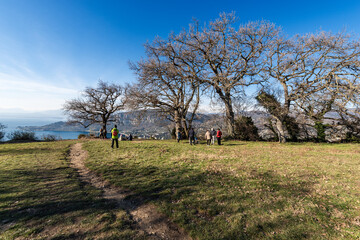 Rocca di Garda, hill overlooking the Lake Garda and the small Garda town, tourist resort on the coast of lake. Verona province, Veneto, Italy, Europe. A group of people relax on a sunny winter day.