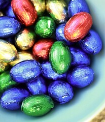 chocolate Easter eggs displayed in many colours on white background stock photo