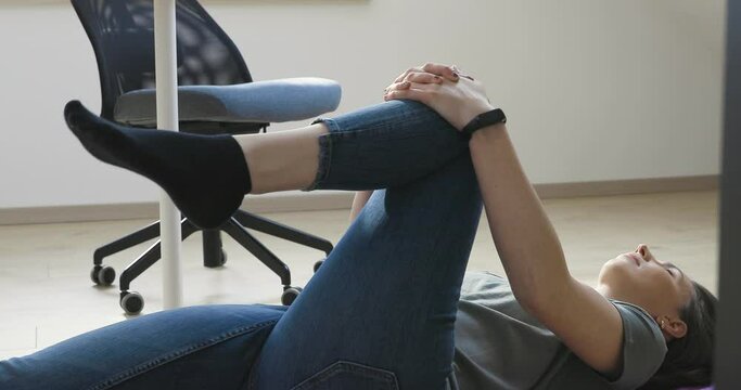 Young women taking a break from work at home office and stretching. Care for body and healthy living.