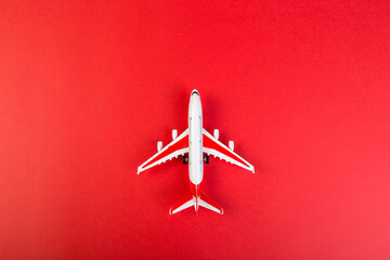 toy model of a modern airplane. tourism and travel concept. red background