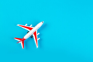 Fototapeta premium Airplane model, airliner with red wings, on a blue background. travel and transport concept