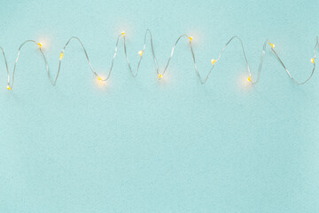 blue background with lit LED garland lights. top view