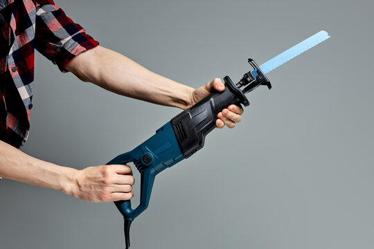 cropped male hand with reciprocating saber saw. construction work. compliance with safety regulations
