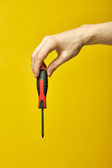 unrecognizable man holding screwdriver in hands pointing down