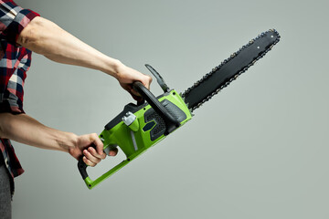 green instrument chainsaw isolated on gray background